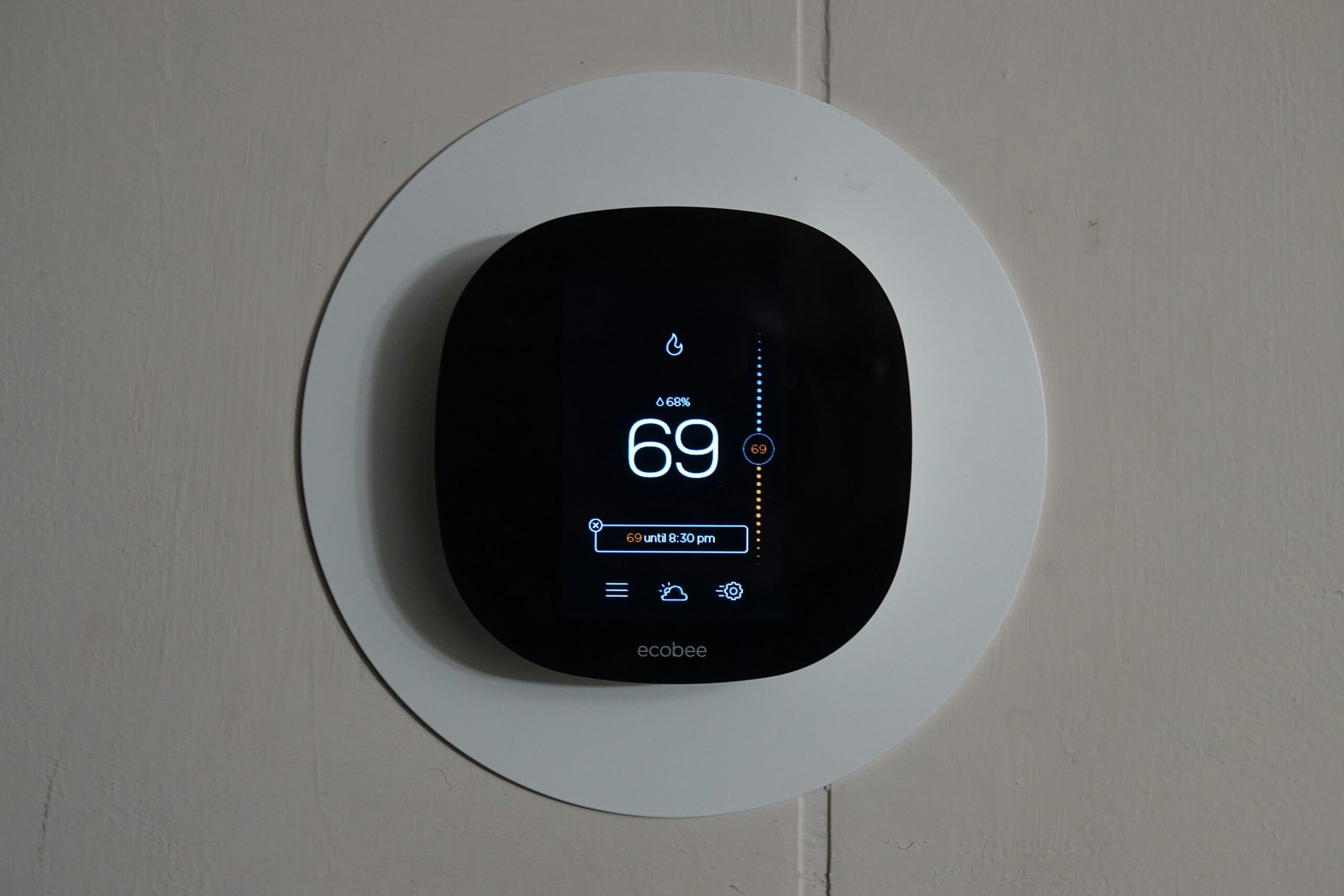 Termostato inteligente instalado en pared de salón moderno